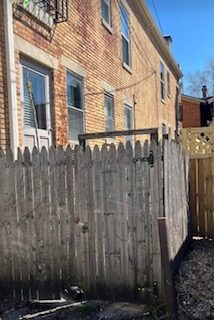 Older wood picket fence in an urban backyard, prepped for repair and replacement