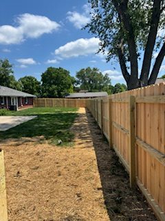 New wood privacy fence running along a side-yard walkway between two homes