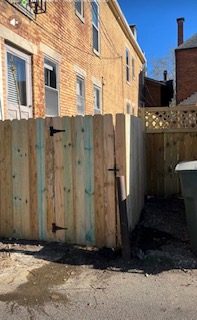 New wood privacy fence with walk-through gate behind an urban Dayton home